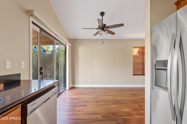 5734 W Commonwealth Pl, Chandler, AZ 85226 - kitchen featuring appliances with stainless steel finishes, wood finished floors, ceiling fan, dark stone countertops, and lofted ceiling