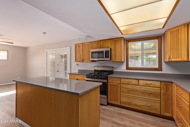 kitchen with a healthy amount of sunlight, a center island, stainless steel appliances, and light hardwood / wood-style floors