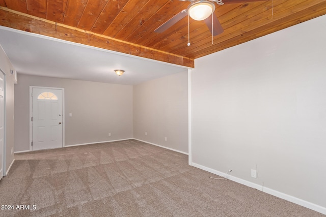 carpeted spare room featuring ceiling fan and wooden ceiling