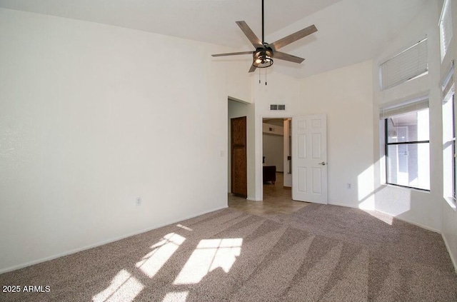 empty room featuring ceiling fan, light colored carpet, and high vaulted ceiling