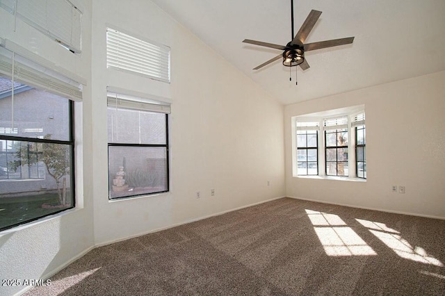 carpeted spare room with ceiling fan, plenty of natural light, and high vaulted ceiling