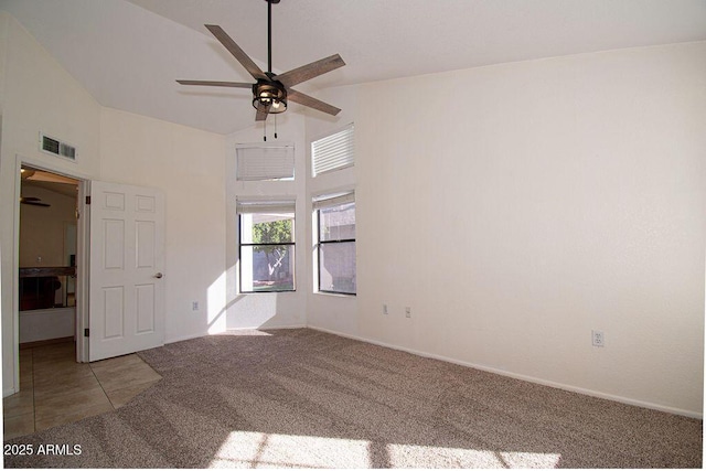 carpeted spare room with ceiling fan and vaulted ceiling