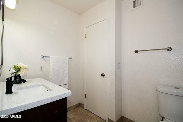 bathroom with toilet, tile patterned floors, and vanity