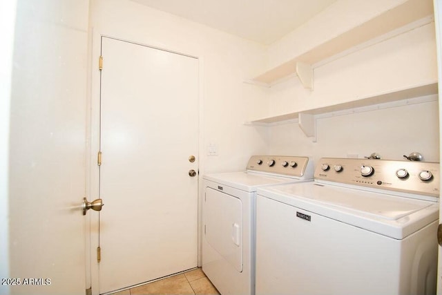 clothes washing area featuring washing machine and dryer and light tile patterned floors