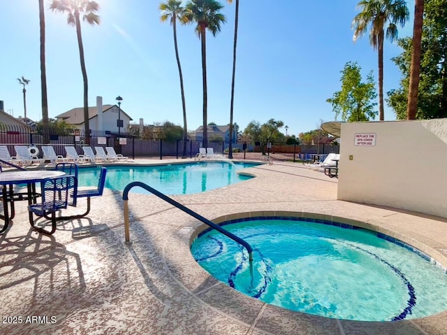 view of swimming pool featuring a hot tub and a patio