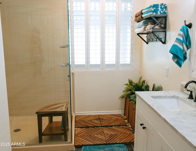 bathroom featuring a shower stall, vanity, and baseboards