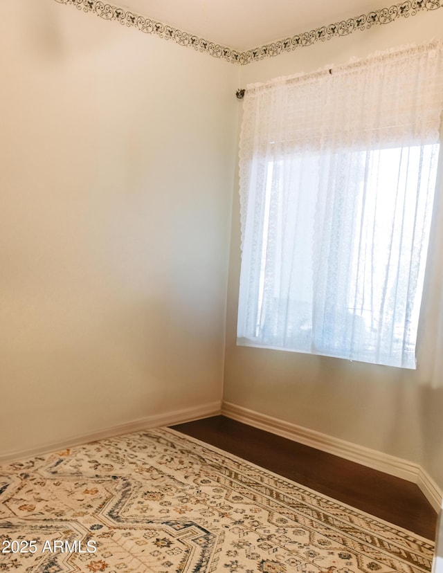 spare room with a wealth of natural light and baseboards