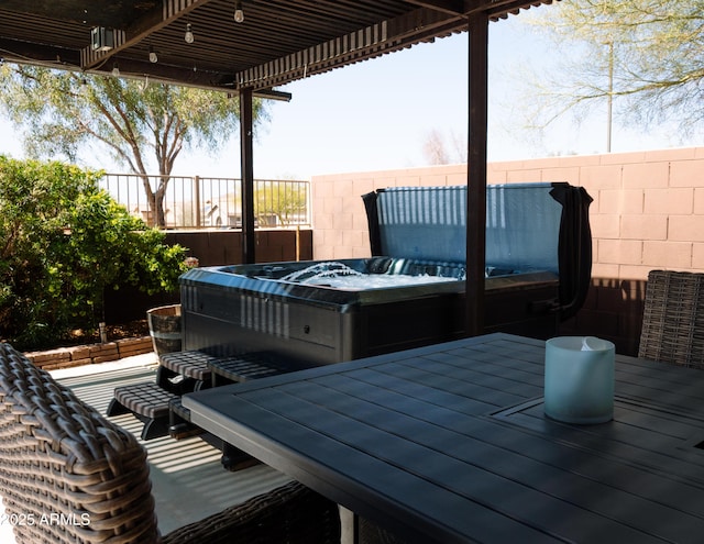 deck with a hot tub and fence