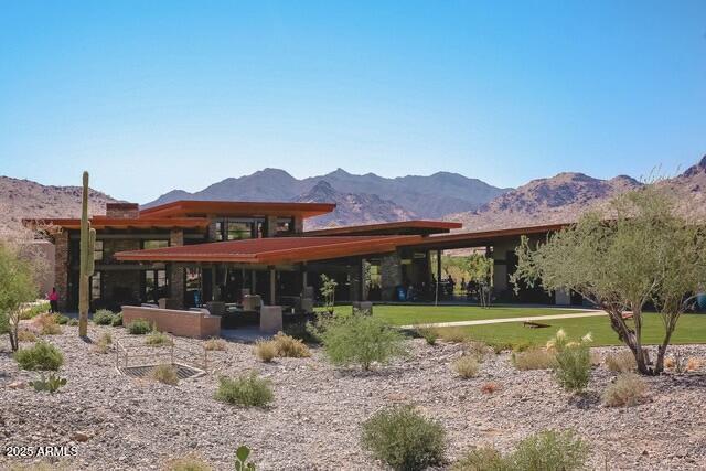 rear view of house with a yard and a mountain view