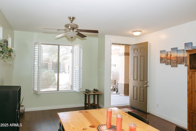 dining space featuring a ceiling fan, baseboards, and dark wood-style flooring