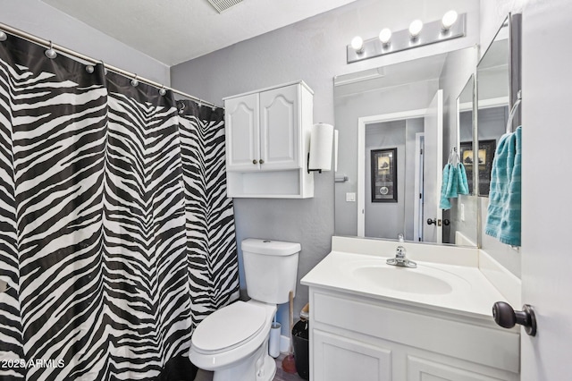 bathroom with vanity, toilet, and walk in shower