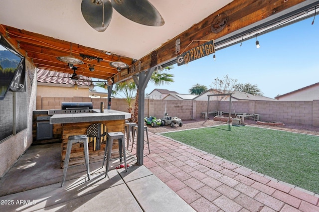 view of patio / terrace with exterior bar, a grill, and ceiling fan