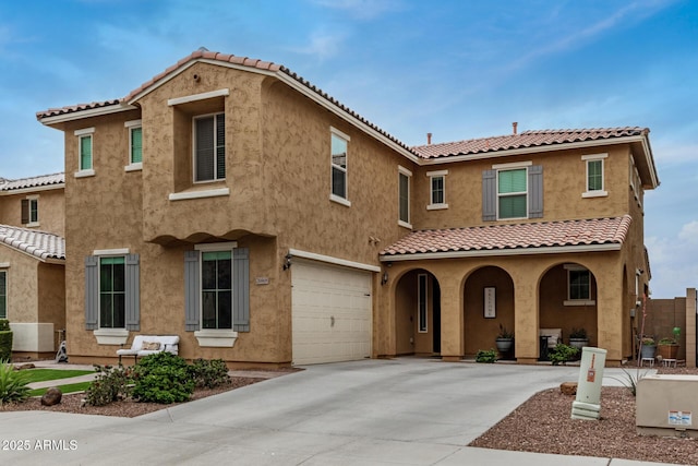 mediterranean / spanish house featuring stucco siding, driveway, a tile roof, a porch, and a garage