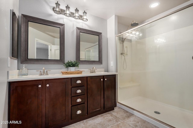 bathroom featuring a sink, an enclosed shower, double vanity, and tile patterned flooring