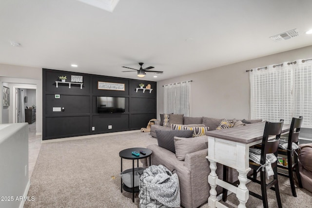 living room with recessed lighting, visible vents, light colored carpet, and a ceiling fan