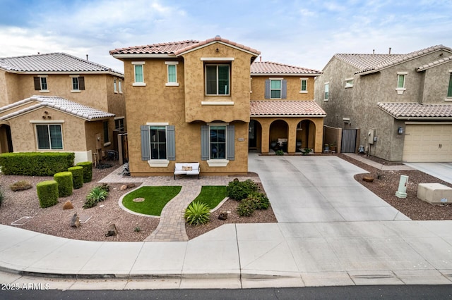 mediterranean / spanish-style home with a tile roof, concrete driveway, and stucco siding