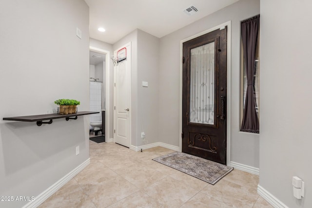 foyer with light tile patterned floors, baseboards, and visible vents