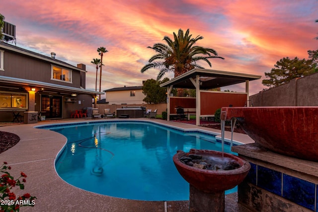 3377 W Grandview Rd, Phoenix, AZ 85053 - pool at dusk with a fenced backyard, a fenced in pool, a patio, and an in ground hot tub