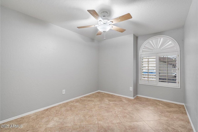 empty room featuring ceiling fan, a textured ceiling, and baseboards