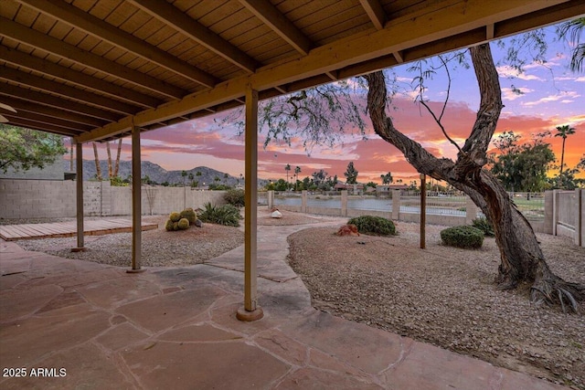 patio terrace at dusk featuring fence