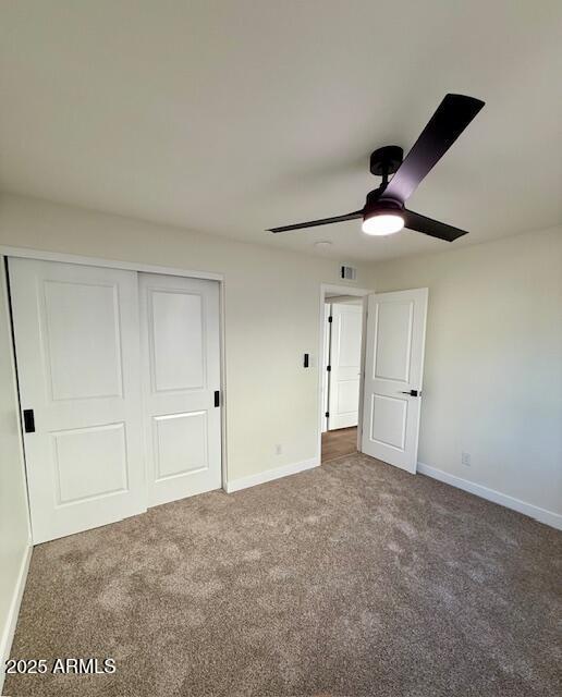 unfurnished bedroom featuring a closet, carpet, and ceiling fan