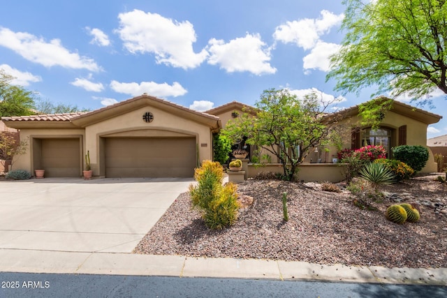 mediterranean / spanish house featuring stucco siding, a tiled roof, driveway, and a garage