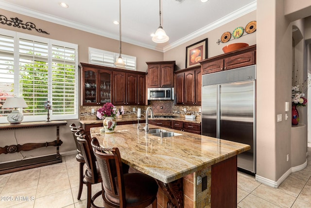 kitchen with a sink, decorative backsplash, appliances with stainless steel finishes, and light tile patterned floors