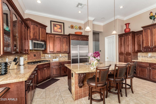 kitchen with a center island, decorative backsplash, light tile patterned flooring, and stainless steel appliances