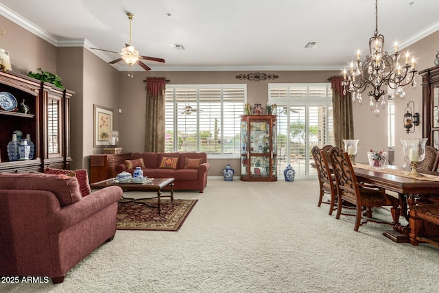 carpeted living room with crown molding, ceiling fan with notable chandelier, and visible vents