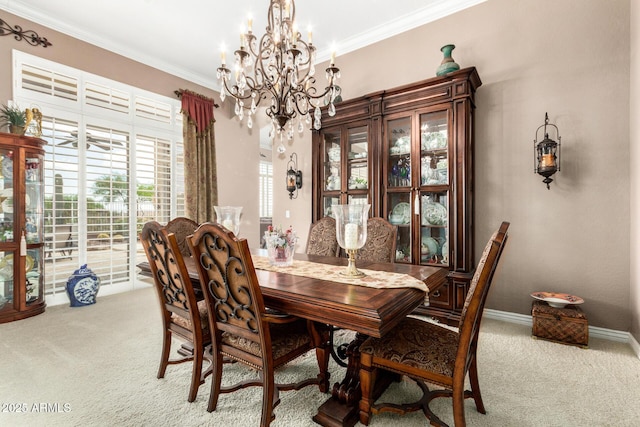 dining area featuring crown molding, carpet flooring, baseboards, and a chandelier