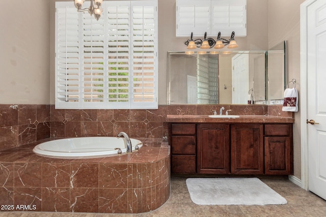 full bathroom with vanity, a garden tub, and a chandelier