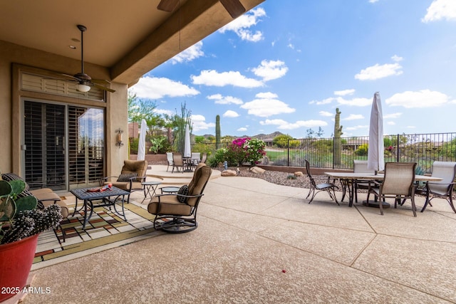 view of patio / terrace with outdoor dining area, a ceiling fan, and fence