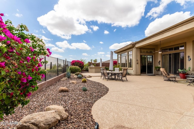 view of patio / terrace with fence, a ceiling fan, and outdoor dining area