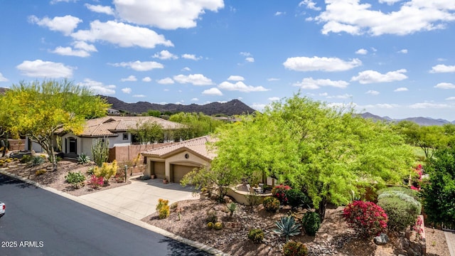 view of front of home featuring a mountain view, an attached garage, concrete driveway, and stucco siding