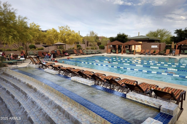 community pool with a patio and fence