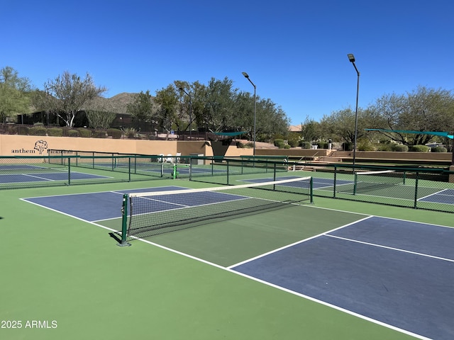 view of tennis court featuring fence and community basketball court