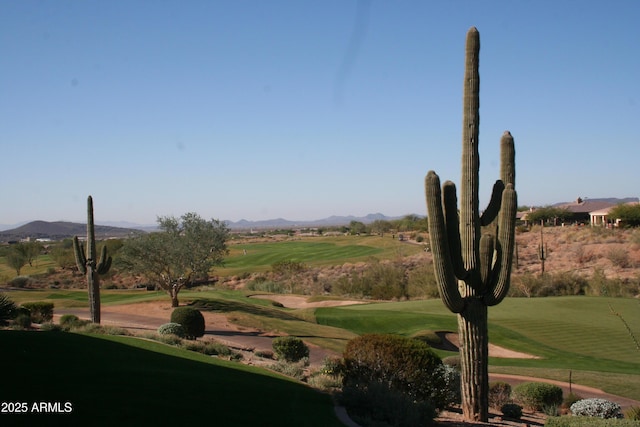 view of property's community with a yard, a mountain view, and golf course view