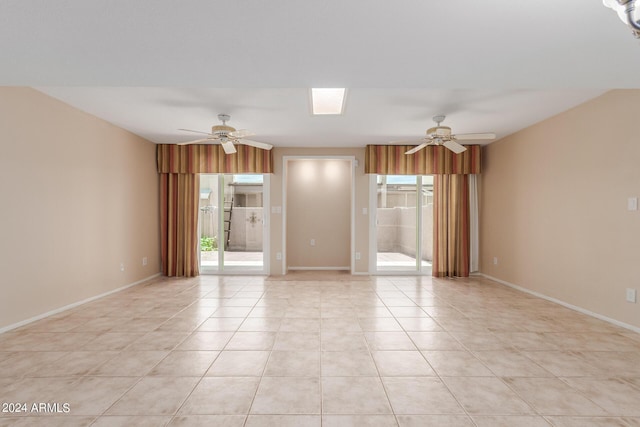 spare room with ceiling fan and light tile patterned flooring