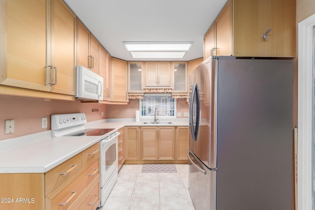 kitchen with light brown cabinetry, sink, light tile patterned floors, and white appliances