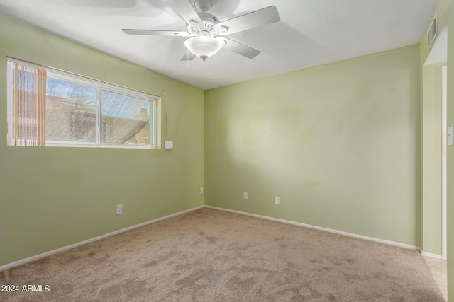 carpeted spare room featuring ceiling fan