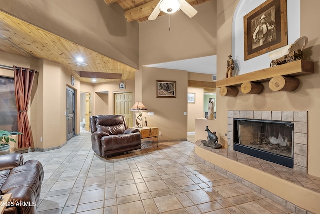 tiled living room with beamed ceiling, a towering ceiling, wooden ceiling, and a fireplace