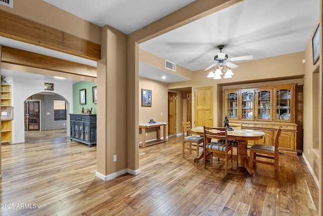 dining space with beamed ceiling, ceiling fan, and light wood-type flooring