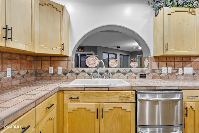 kitchen featuring light brown cabinetry, sink, tasteful backsplash, tile countertops, and dishwasher