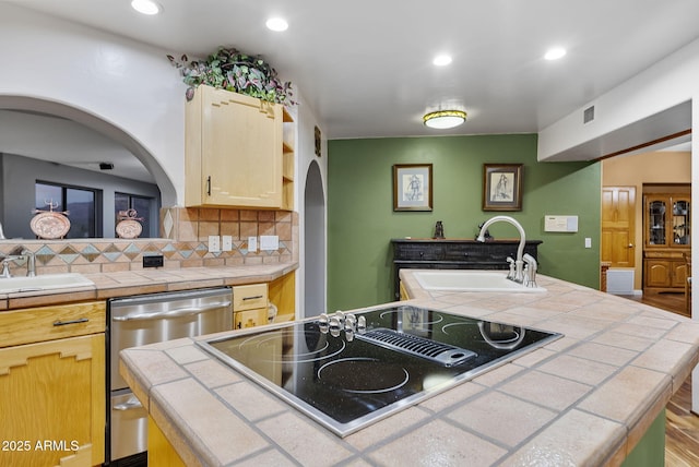 kitchen with sink, tile counters, black electric stovetop, and a kitchen island