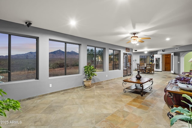 living room featuring a mountain view and ceiling fan