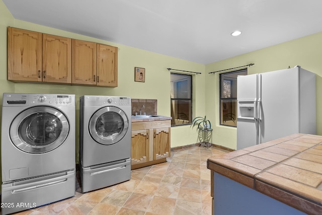 laundry area featuring cabinets, sink, and washing machine and clothes dryer