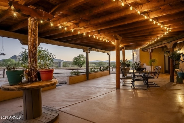 patio terrace at dusk featuring a mountain view