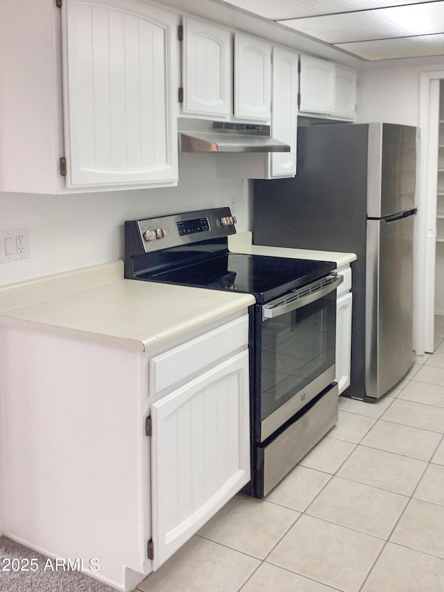 kitchen with light tile patterned floors, appliances with stainless steel finishes, and white cabinetry