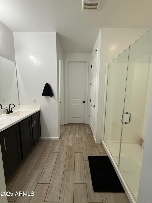 bathroom featuring walk in shower and vanity