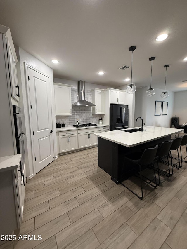 13342 W Lariat Ln, Peoria, AZ 85383 - kitchen with sink, white cabinetry, a center island with sink, appliances with stainless steel finishes, and wall chimney range hood